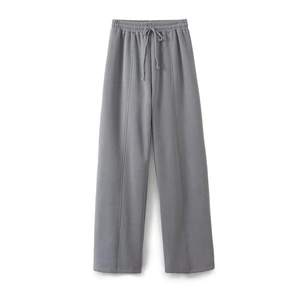 Detail showing grey knit high-waist drawstring trousers with vertical front seams