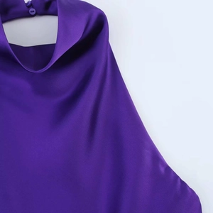 Detailed close-up of dark purple satin halter neck with silk texture and single button closure