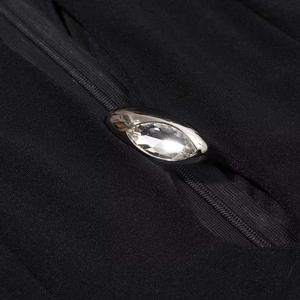 Detailed macro view of black fabric featuring an invisible zipper and silver crystal fastener