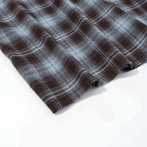 Detail shot of vintage plaid shirt sleeve showing woven fabric texture in brown and blue