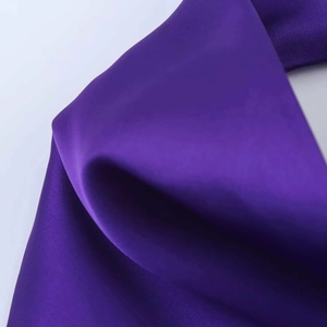 Macro shot of dark purple satin fabric showing smooth silk texture and elegant sheen