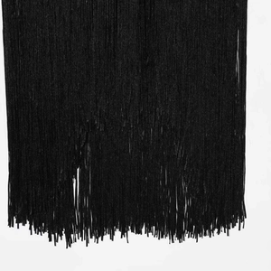 Minimalist black halter dress with elegant fringe detailing and flowing tassel hemline