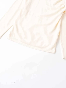 Close-up of the textured off-white faux wool fabric and neat hem stitching of the top