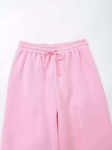 Detail of pink high-waisted joggers with elastic drawstring waist and vertical seam stitching