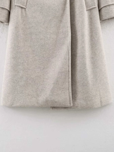 Detailed close-up of light oat wool coat featuring flap pocket and premium texture