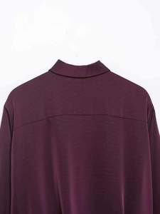 Detail view of the back shoulder seam on this vintage burgundy satin short shirt