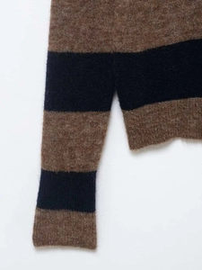 Close-up of brown and navy striped knit sweater texture with soft side slit detail