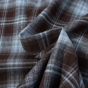 Close-up of vintage brown and light blue plaid fabric with soft flannel texture