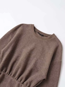 Macro detail of brown ribbed knit fabric texture and elastic waistband of the dress