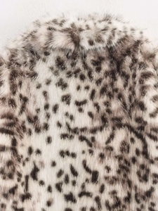 Gros plan sur la texture en fausse fourrure léopard d'un manteau d'automne épais