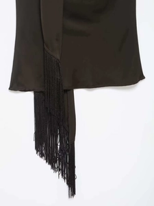 Détail de la texture satinée et des franges fluides sur le haut élégant dos nu