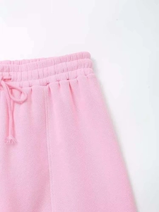 Detail of pink lounge pants featuring an elastic drawstring waistband and soft knit fabric
