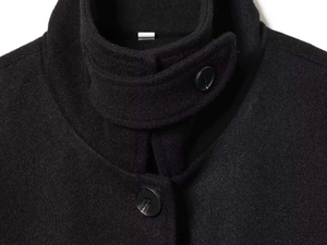 Detail of black wool coat stand collar with windproof buckle and textured fabric