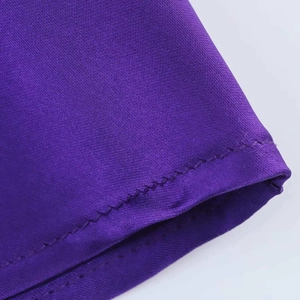 Macro shot of purple satin fabric featuring high-quality double-stitched hem details
