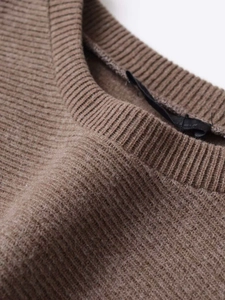 Detailed close-up of brown knit dress neckline with premium rib stitching texture