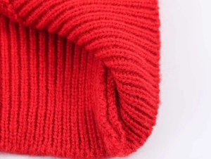 Detailed macro shot of thick red ribbed knit fabric with soft wool texture and warm feel