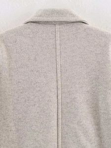 Macro shot of light gray wool blend coat fabric texture and back seam craftsmanship