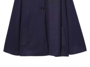 Detail view of navy blue wool coat featuring side pockets and a single round button