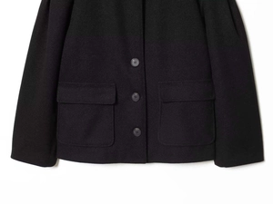 Close-up of black wool coat featuring high-quality fabric texture and three-button closure