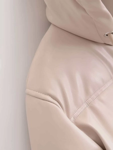 Detail view of beige faux leather hooded jacket featuring precise double-stitch seams