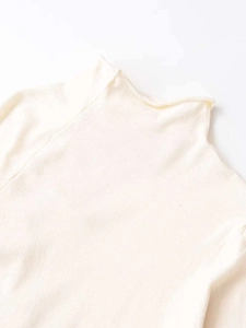 Close-up of off-white knitted turtleneck sweater showing premium fabric texture and seams