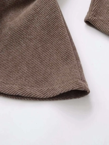 Detailed macro view of dark brown ribbed knit fabric showing the premium textured weave