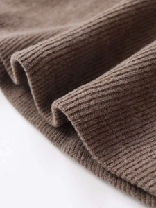 Macro shot of dark brown ribbed knit fabric texture with soft vertical pleats