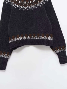 Detailed view of Nordic jacquard pattern and ribbed cuffs on charcoal knit sweater