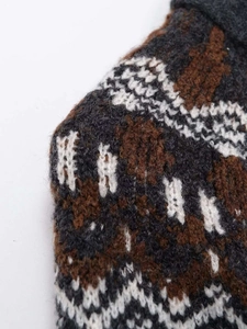 Detailed close-up of retro geometric wave jacquard knit texture in charcoal and coffee