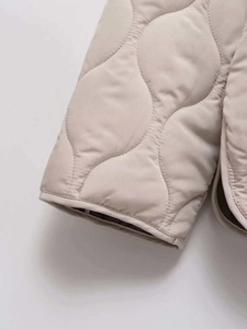 Detail of onion quilted jacket showing high-quality stitching and elastic cuffs in beige