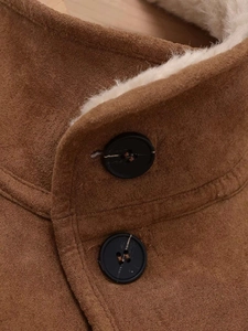 Detail eines karamellbraunen Wildlederimitat-Kragens mit weichem Lammfellfutter und Knöpfen