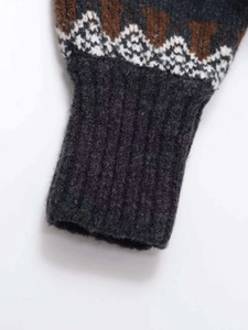 Detailed macro view of charcoal grey knit sweater cuff with ribbed texture and wave pattern