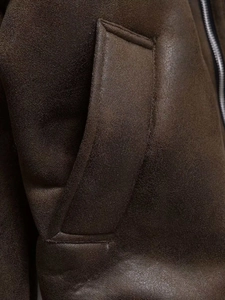 Detailed view of metal zipper and pocket seam on the brown faux suede shearling jacket