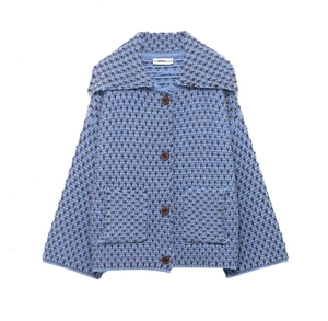 Détail du cardigan en maille gaufrée bleu et marron avec boutons en bois et poches plaquées