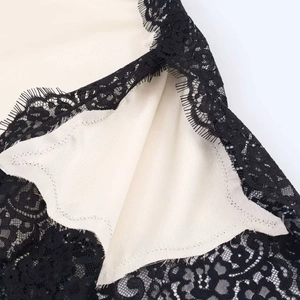 Detail of satin fabric with eyelash lace trim and floral cutout patterns on camisole