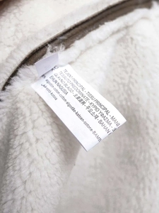 Close-up of the garment care label showing cotton content and soft shearling lining detail