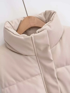 Close-up of the stand-up collar and hidden zipper on this beige faux leather puffer vest