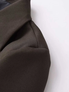Detailed macro view of dark coffee blazer shoulder seam and twill fabric texture