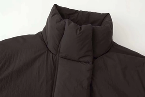 Detail shot of black puffer jacket showing high stand collar and matte windproof fabric texture