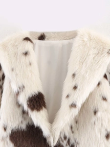 Close-up of fluffy cow print faux fur texture and smooth inner lining on winter coat