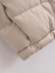 Close-up of beige quilted faux leather vest hem showing high-quality stitching detail