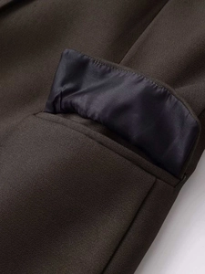 Detail of a brown blazer pocket with textured twill fabric and silky satin lining