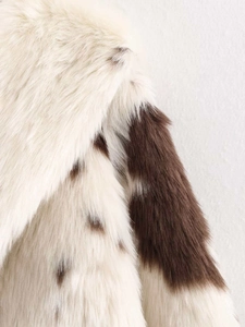 Detailed close-up of fluffy faux fur texture with vintage cow print on winter jacket shoulder