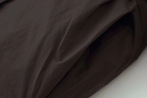 Detailed close-up of side pocket and smooth stitching on a loose winter puffer jacket