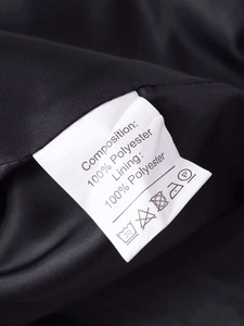 Detail view of the wash care label for the blazer made of 100% polyester fabric