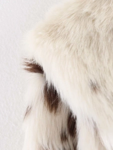 Close-up macro view of soft faux fur texture with vintage cow print pattern on a winter jacket