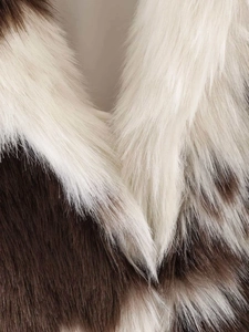 Macro shot of fluffy cow print faux fur texture with brown and white plush material