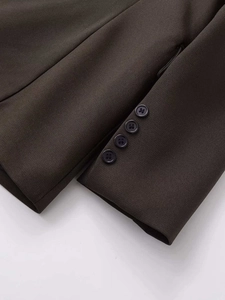 Detailed view of dark brown blazer cuffs featuring four decorative buttons and twill texture