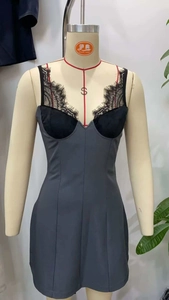 Detailed view of black lace trim on a slim fit grey dress with deep V-neckline