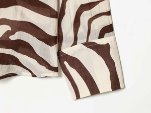 Détail du tissu à motif zèbre avec des coutures fines sur les poignets de la chemise